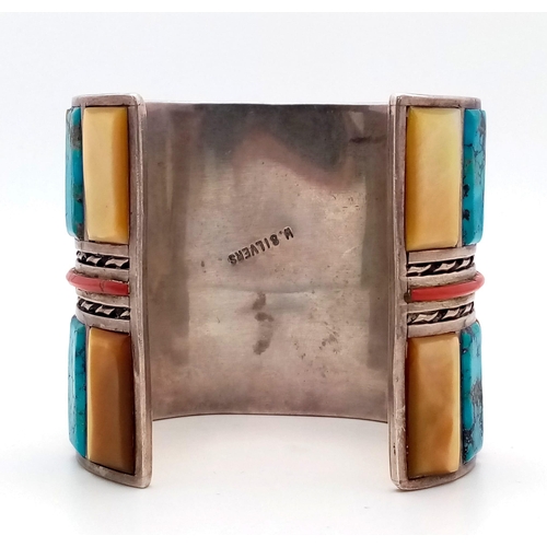 143 - A Vintage Silver Native American Cuff Bangle. Inlaid turquoise, mother of pearl and red coral create... 