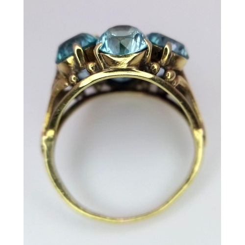 395 - A 9K YELLOW GOLD, BLUE AND PINK STONE CLUSTER RING. 4.2G. SIZE I