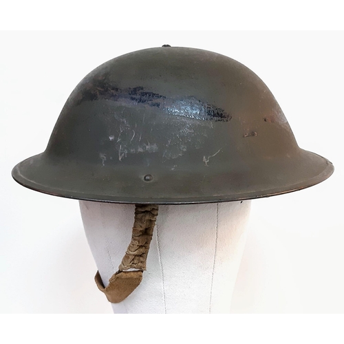 243 - 1943 Dated British MK II Helmet. Original Paint. Makers Marked RO & CO. With original chin strap. Al... 