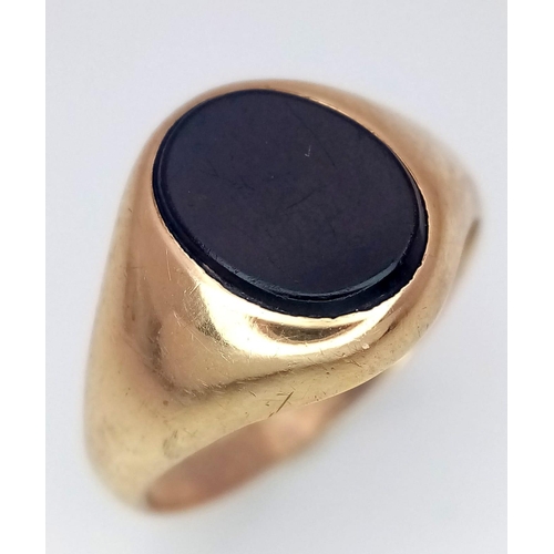 1039 - A 9 K yellow gold cygnet ring with a black, oval onyx.  Ring size: K, weight: 2.5 g.