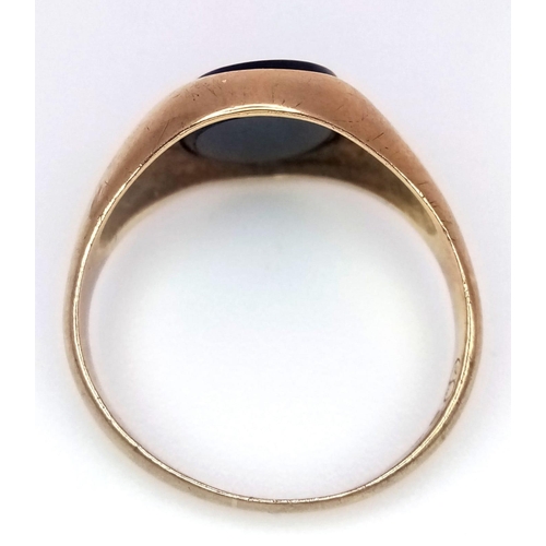 1039 - A 9 K yellow gold cygnet ring with a black, oval onyx.  Ring size: K, weight: 2.5 g.