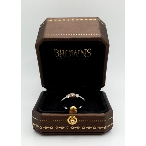 227 - A Browns Designer 18K White Gold and Diamond Trilogy Ring. Central brilliant round cut 0.30ct champa... 