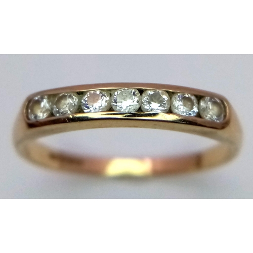 576 - A 9 K yellow gold ring with a band of round cut cubic zirconia. Size: P, weight: 1.6 g.