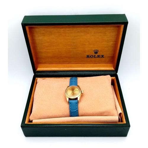 934 - An 18k Gold Rolex Oyster Perpetual Ladies Watch. Blue leather strap. 18k gold case - 25mm. Gold tone... 