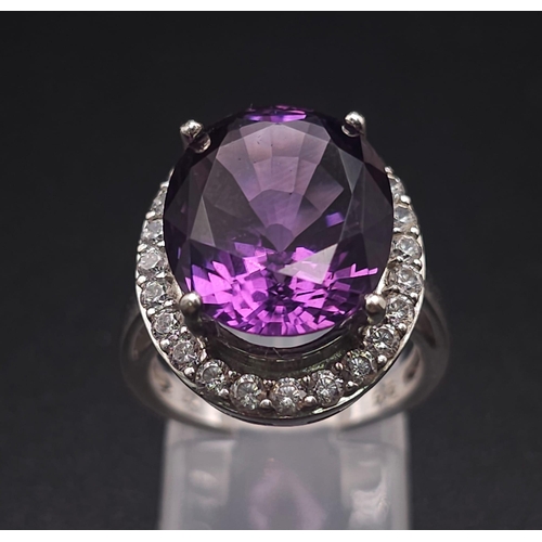 1103 - A STUNNING SILVER RING WITH LARGE AMETHYST SURROUNDED BY SPARKLING ZIRCONIA STONES .  6.1gms   size ... 