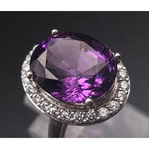 1103 - A STUNNING SILVER RING WITH LARGE AMETHYST SURROUNDED BY SPARKLING ZIRCONIA STONES .  6.1gms   size ... 