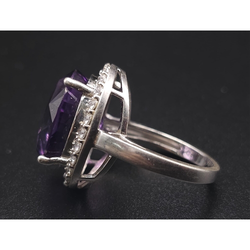 1103 - A STUNNING SILVER RING WITH LARGE AMETHYST SURROUNDED BY SPARKLING ZIRCONIA STONES .  6.1gms   size ... 