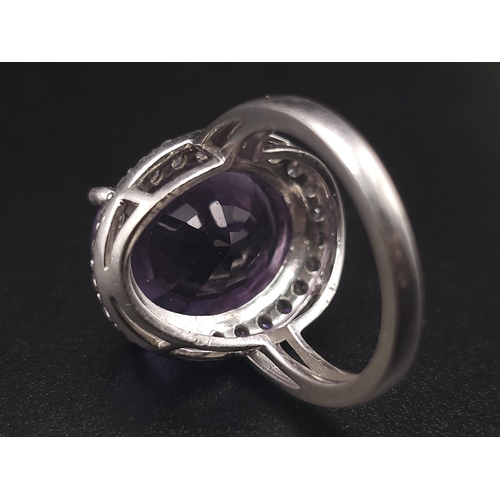 1103 - A STUNNING SILVER RING WITH LARGE AMETHYST SURROUNDED BY SPARKLING ZIRCONIA STONES .  6.1gms   size ... 