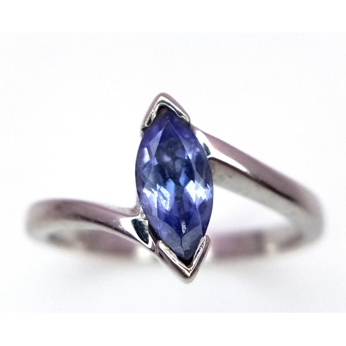 1151 - An 18K White Gold Tanzanite Crossover Ring. Size J. 2.55g total weight.