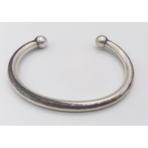 1384 - A SOLID STERLING SILVER TORQUE BANGLE.  56.3G