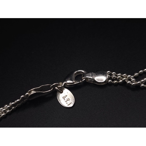 414 - A sterling silver triple chain necklace with a magnifying glass holder pendant decorated with cubic ... 