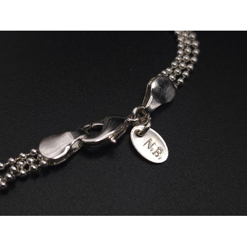 414 - A sterling silver triple chain necklace with a magnifying glass holder pendant decorated with cubic ... 