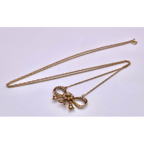 1027 - A 9KT Yellow Gold Necklace with a beautiful Bow, Pearl set Pendant. 
Measuring 50cm in length, this ... 