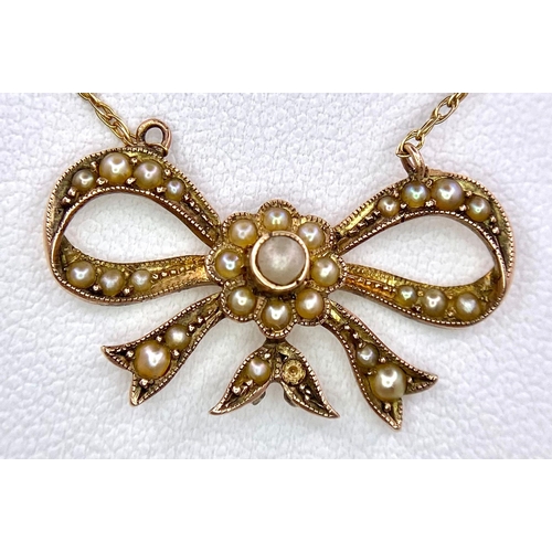 1027 - A 9KT Yellow Gold Necklace with a beautiful Bow, Pearl set Pendant. 
Measuring 50cm in length, this ... 