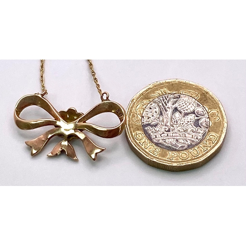 1027 - A 9KT Yellow Gold Necklace with a beautiful Bow, Pearl set Pendant. 
Measuring 50cm in length, this ... 