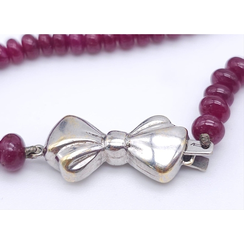 1077 - A superb graduating Ruby Red Stone Beaded Necklace with a 18kt White Gold, Diamond Set Bow Clasp. Me... 