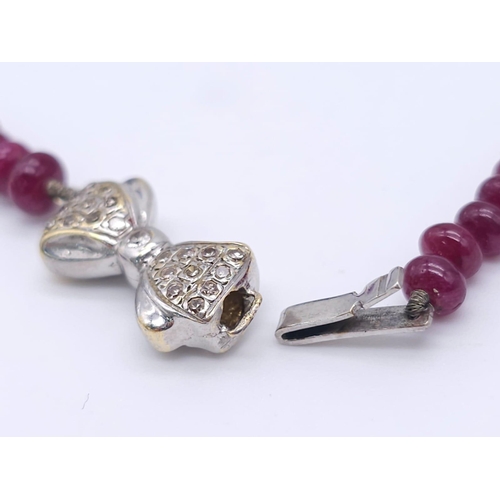 1077 - A superb graduating Ruby Red Stone Beaded Necklace with a 18kt White Gold, Diamond Set Bow Clasp. Me... 