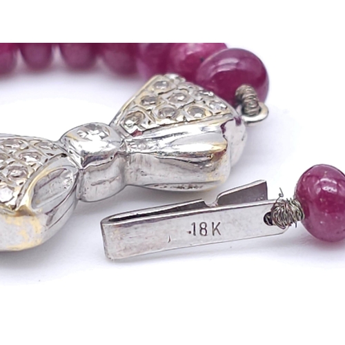 1077 - A superb graduating Ruby Red Stone Beaded Necklace with a 18kt White Gold, Diamond Set Bow Clasp. Me... 