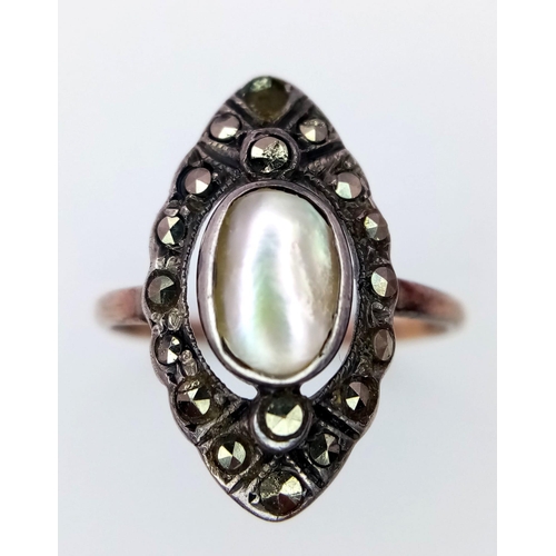 159 - An antique yellow gold ring with an oval Mother of Pearl surrounded by marcasite. Ring size: I, weig... 