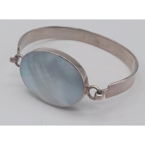 1341 - A vintage 925 silver click-on bangle with large Mother of pearl centre. Total weight 22.8G.