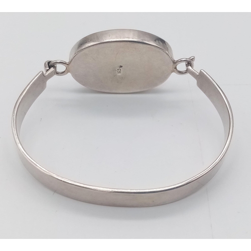 1341 - A vintage 925 silver click-on bangle with large Mother of pearl centre. Total weight 22.8G.