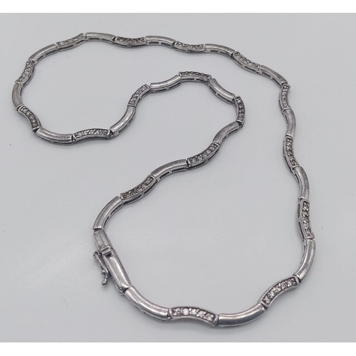 744 - A vintage 925 silver Zirconia link wave necklace with London hallmark. Total weight 15.7G. Total len... 