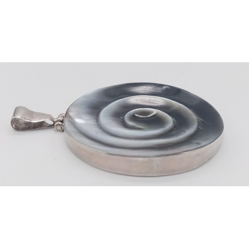 778 - A vintage 925 silver Mother of Pearl shell spiral pendant. Total weight 12.7G. Diameter: 4.7cm.