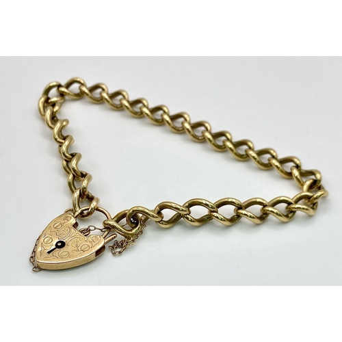 86 - A 9k yellow gold traditional charm bracelet with heart padlock. 18cm. 19g