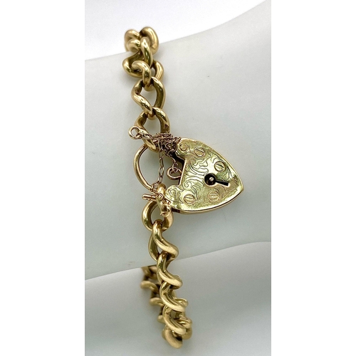 86 - A 9k yellow gold traditional charm bracelet with heart padlock. 18cm. 19g