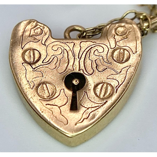 86 - A 9k yellow gold traditional charm bracelet with heart padlock. 18cm. 19g