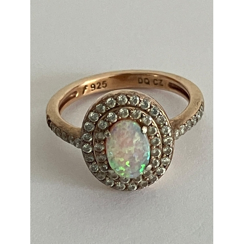 1520 - Stunning OPAL and SILVER RING Consisting a light reflecting Opal set to centre, with sparkling doubl... 