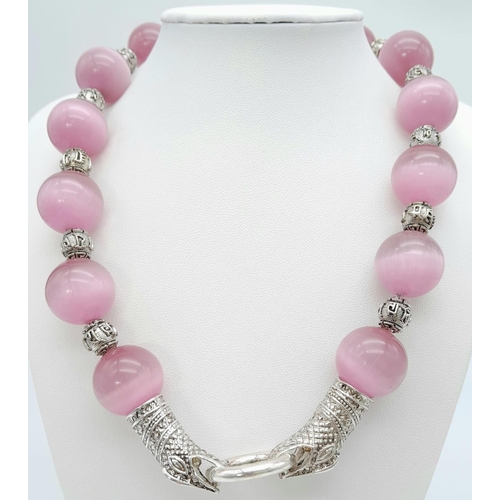 161 - A spectacular, large beaded (18 mm), pink cat’s eyes necklace with a Chinese silver snake clasp and ... 