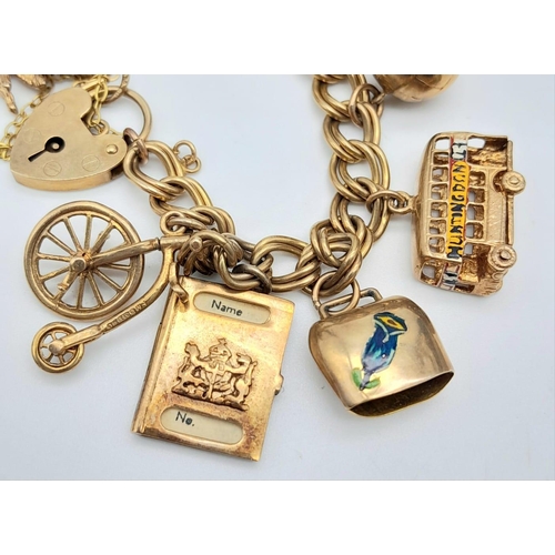 207 - A 9K GOLD CHARM BRACELET SPORTING 12 INTERESTING CHARMS TO INCLUDE PASSPORT, £1 NOTE , LONDON BUS AN... 