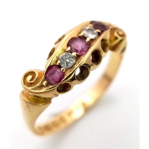 235 - AN ANTIQUE 18K GOLD RING WITH DELICATE SCROLL WORK ENCASING DIAMONDS AND PINK RUBY .  4.4gms   size ... 