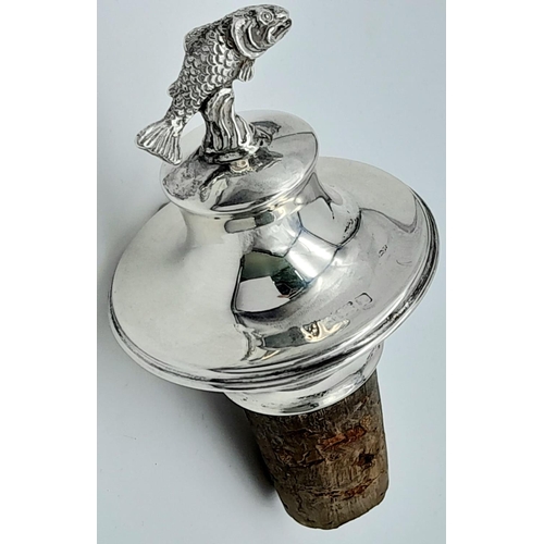 1248 - AN UNUSUAL BOTTLE STOP, A CORK WITH SOLID SILVER TOP WITH FLYING FISH .   39.6gms