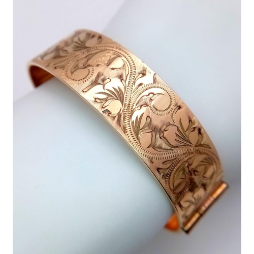 738 - A vintage 50 MICRON 9CT rolled gold click-on bangle with flower motif. Total weight 29.2G.