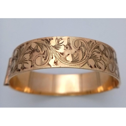 738 - A vintage 50 MICRON 9CT rolled gold click-on bangle with flower motif. Total weight 29.2G.