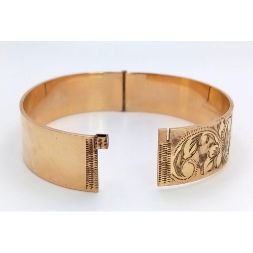 738 - A vintage 50 MICRON 9CT rolled gold click-on bangle with flower motif. Total weight 29.2G.