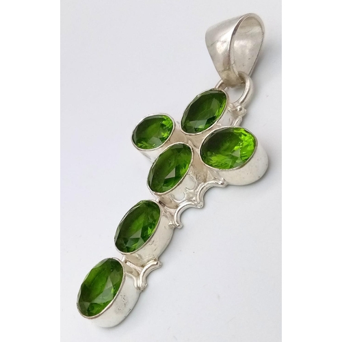 1234 - A MODERN SILVER CROSS PENDANT DECORATED WITH 6PERIDOT STONE .10.12gms