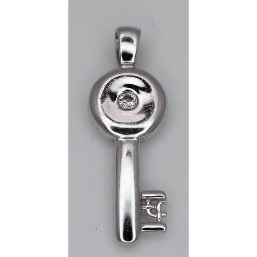 1353 - AN 18K WHITE GOLD DIAMOND SET KEY CHARM / PENDANT. 1.6G