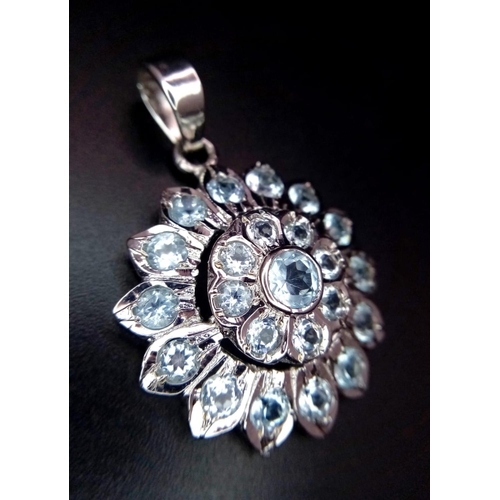 1017 - A Blue Topaz Decorative Floral Pendant set in 925 Sterling silver. 8ctw. W-7.5g. 4cm. Comes with a p... 