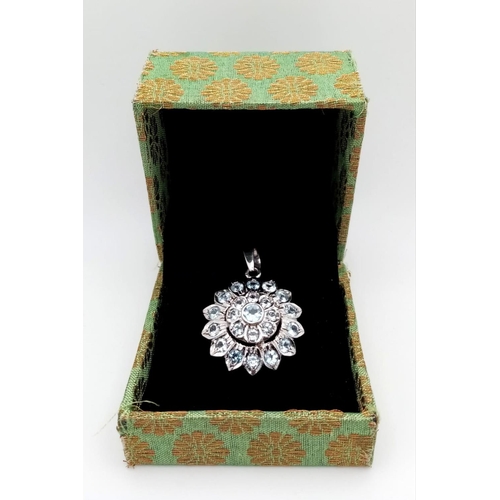 1017 - A Blue Topaz Decorative Floral Pendant set in 925 Sterling silver. 8ctw. W-7.5g. 4cm. Comes with a p... 