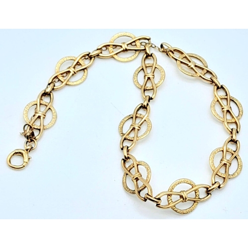 702 - A 9k yellow gold openwork detailed bracelet with safety chain. 19cm length. 6.6g.