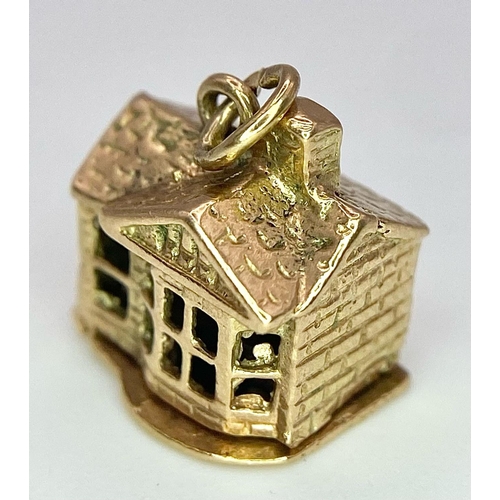 724 - A 9K yellow gold opening house charm. 2.7g