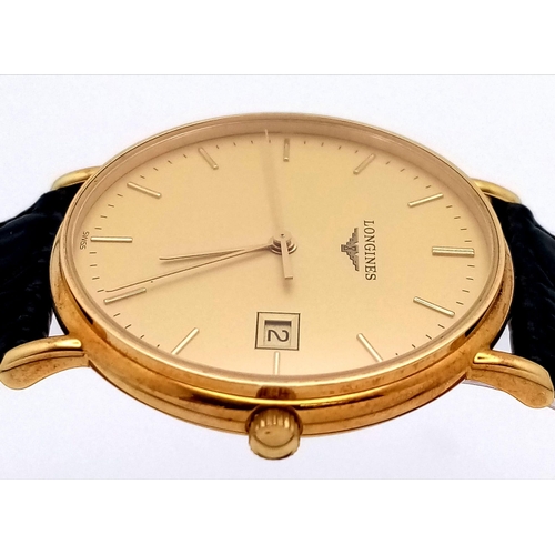 24 - A Longine 18K Gold Cased Gents Watch. Black leather strap. 18k gold case - 33mm. Gilded dial with da... 