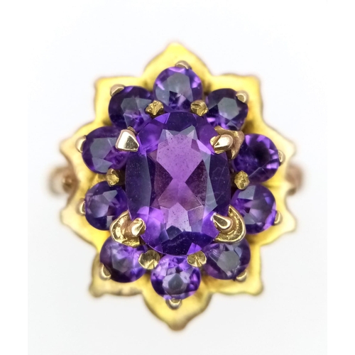 68 - A Vintage 9K Yellow Gold Amethyst Ring. Central oval cut amethyst with an amethyst halo. Size M. 4.2... 