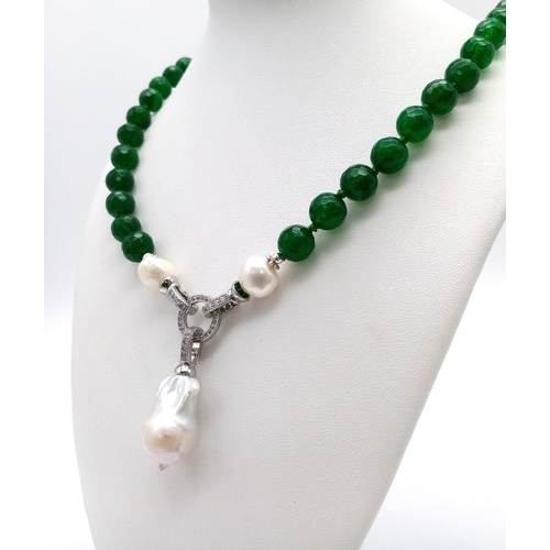 1324 - A Green Jade Necklace with a Baroque Pearl Pendant. 10mm green jade beads lead to a baroque pearl pe... 