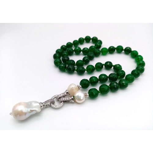 1324 - A Green Jade Necklace with a Baroque Pearl Pendant. 10mm green jade beads lead to a baroque pearl pe... 