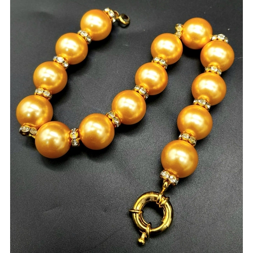 929 - A Golden South Sea Pearl Shell Bracelet - White stone spacers. 18cm length. 12mm beads.