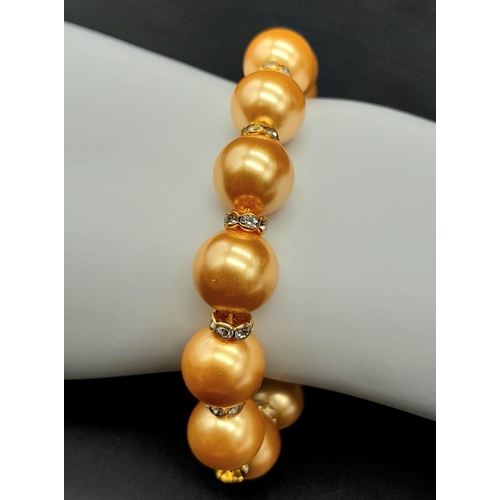 929 - A Golden South Sea Pearl Shell Bracelet - White stone spacers. 18cm length. 12mm beads.